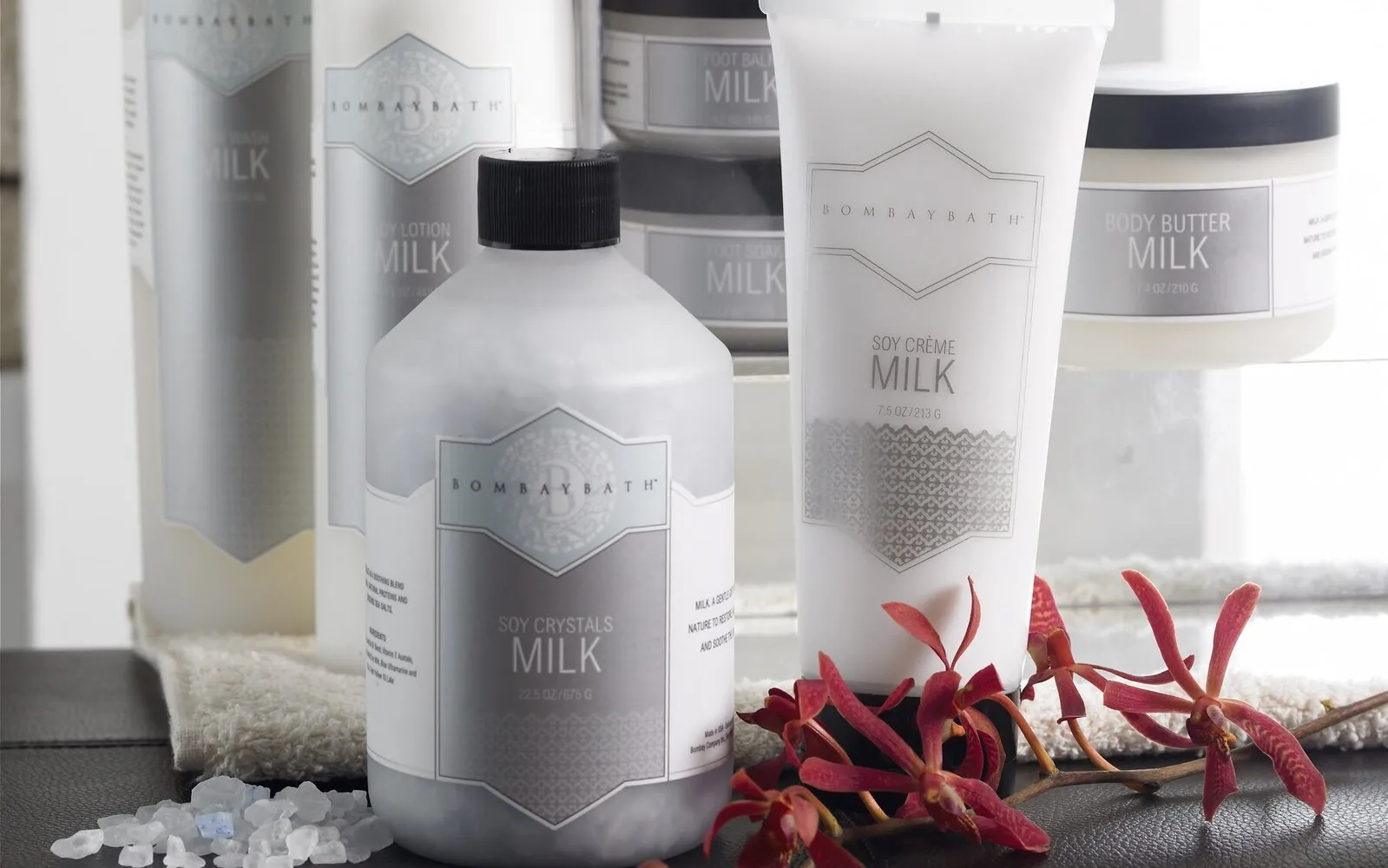 Bombay Bath Milk line — soy crystals, body lotion, and soy crème packaging with red orchids and bath salts.