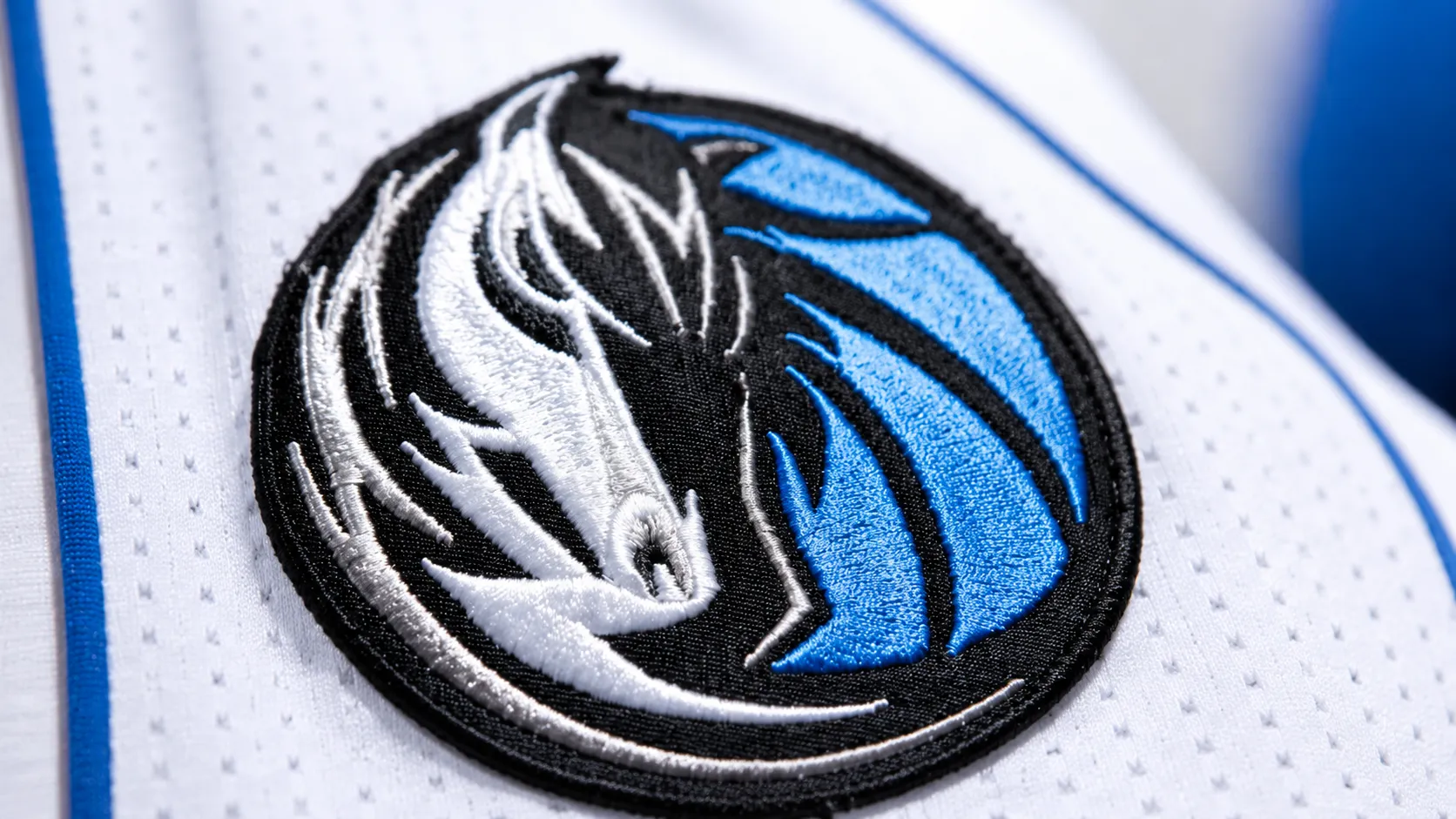Dallas Mavericks horse-head crest embroidered on a white jersey.
