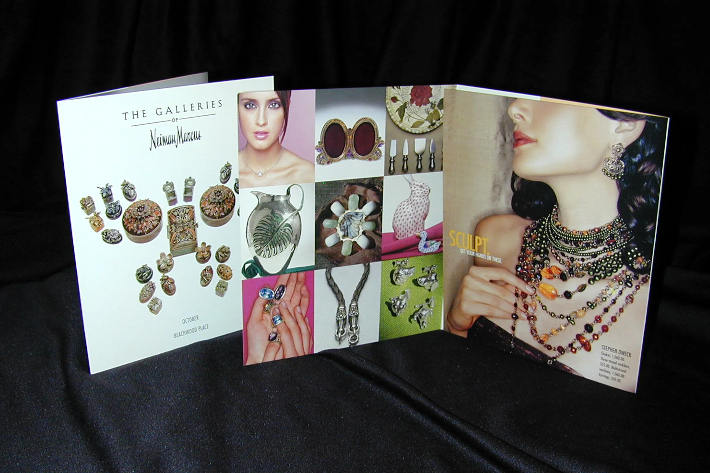 The Galleries of Neiman Marcus printed brochure standing on black, showing a grid of product photography and a jewelry feature spread.