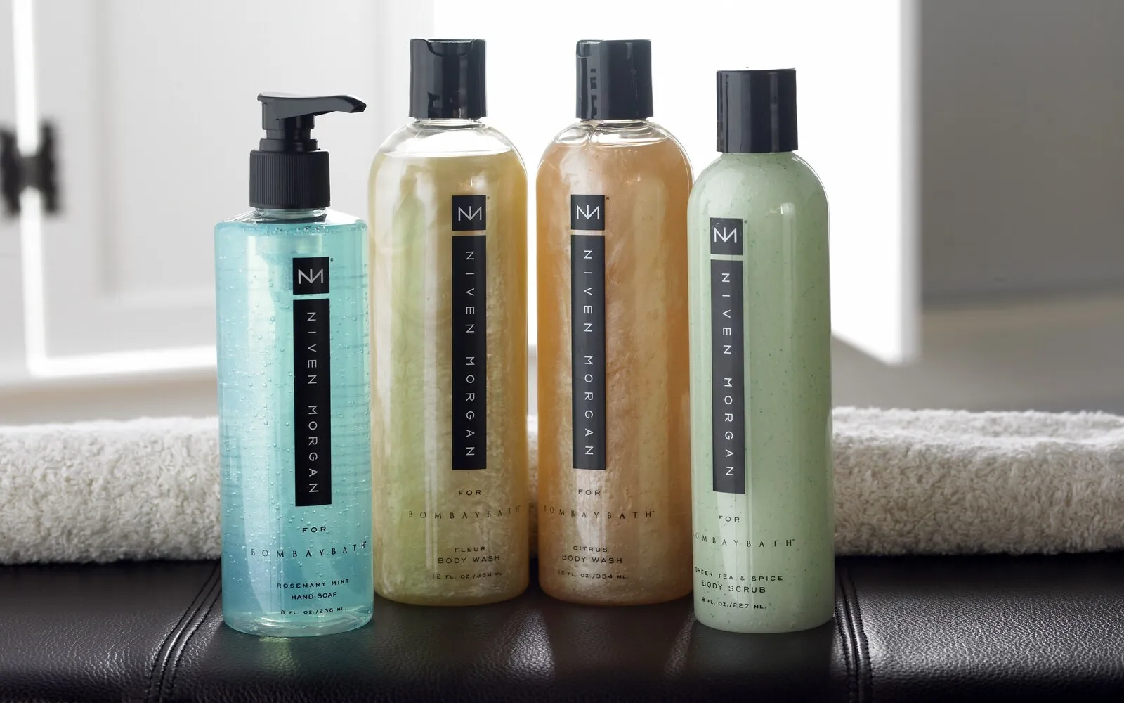 Niven Morgan for Bombay Bath collection — hand soap, body washes, and body scrub in clear bottles.